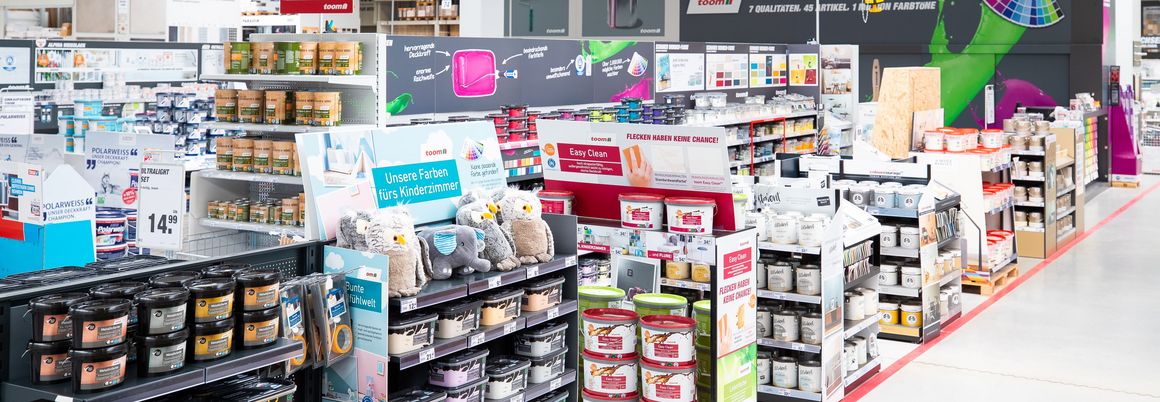 Regalreihen mit Farbeimern und Zubehör in einem Baumarkt